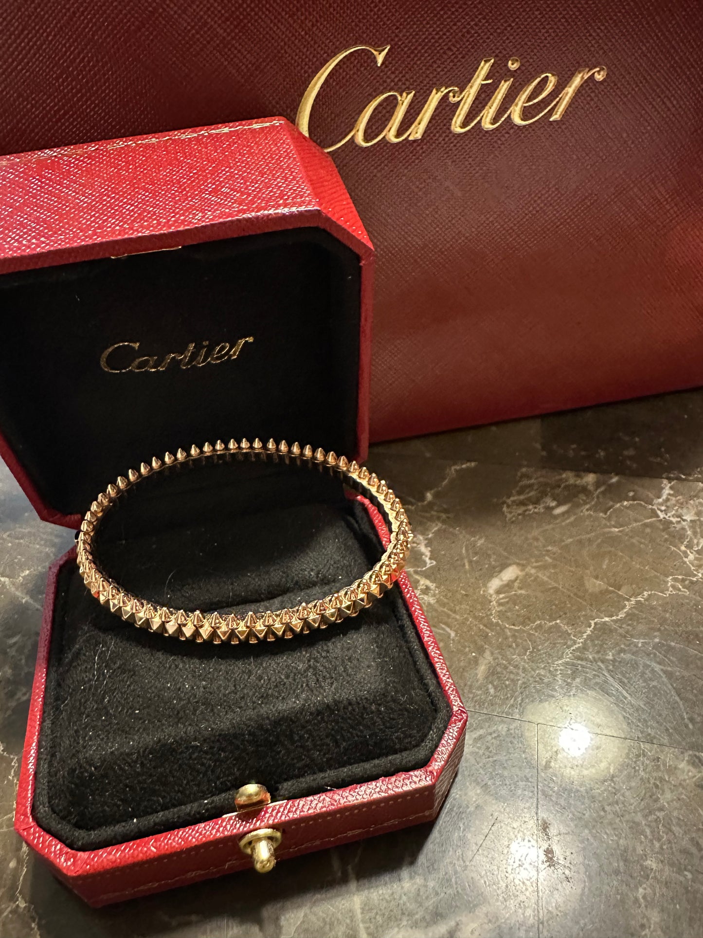 Cartier bullet design, rose gold. Pictured with Bulgari rose ring, size 6, not included.